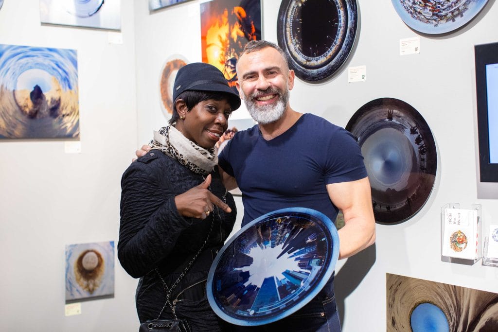 a man and a woman are posing for a picture and the man is holding a plate with a picture of a city on it
