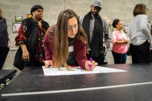 a woman is writing on a piece of paper on a table .