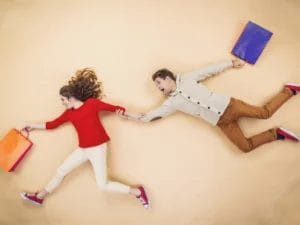 a man and a woman are running with shopping bags