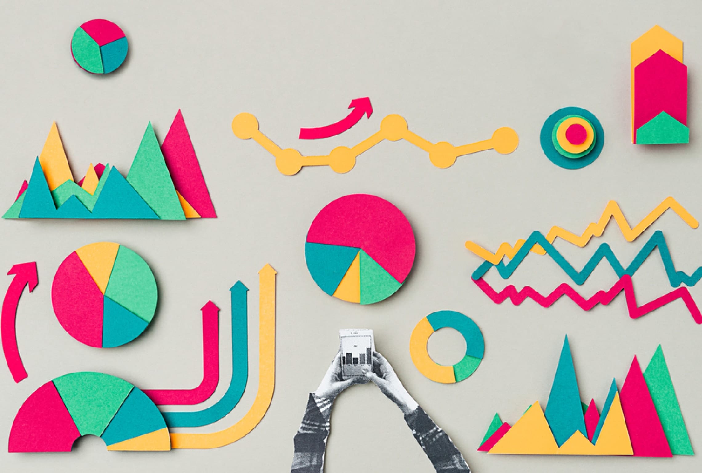 a person holding a cell phone surrounded by colorful paper graphs