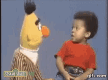 a little boy talking to bert from sesame street