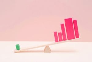 a green block is on a seesaw with pink bars