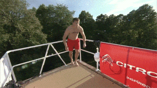 a man jumps off a diving board in front of a citroen sign