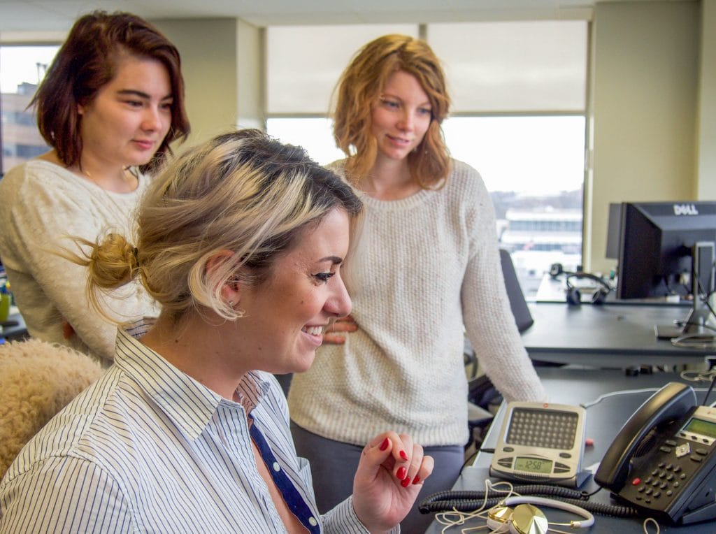 Nutshell support team standing by a desk 