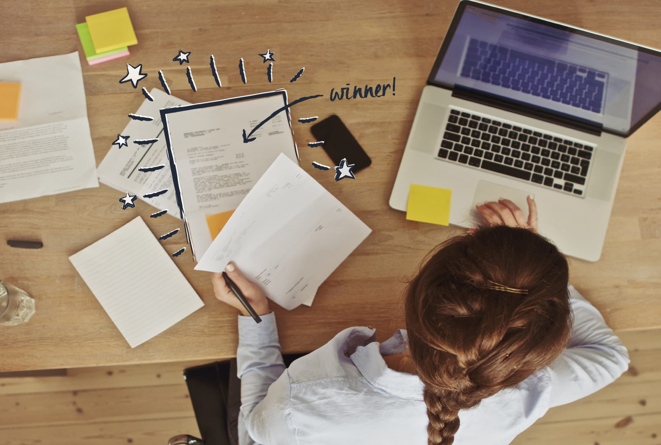 a woman sits at a desk with papers and a laptop with the word winner written on the screen