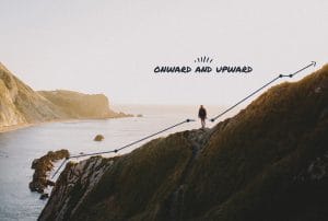 a man stands on a cliff overlooking the ocean with the words onward and upward below him