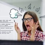 en kvinne med briller skriker foran en dataskjerm