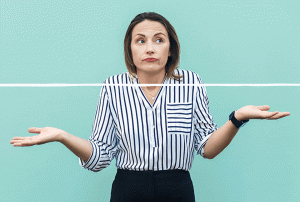 a woman in a striped shirt is shrugging her shoulders