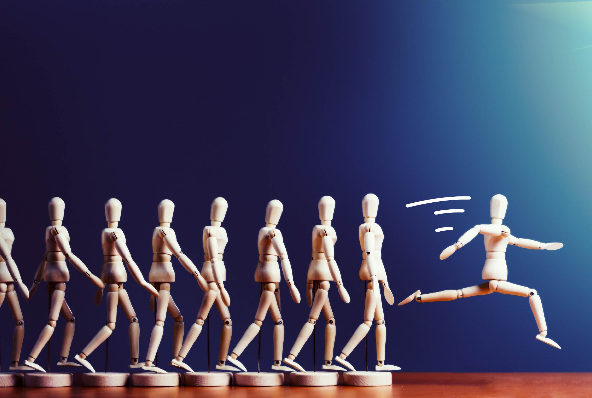 a group of wooden mannequins are walking and one is running