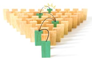 een rij houten dominostenen met groene blokken die met elkaar verbonden zijn