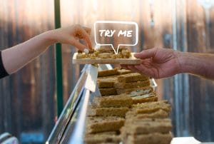 a person holding a tray of food with a speech bubble that says try me