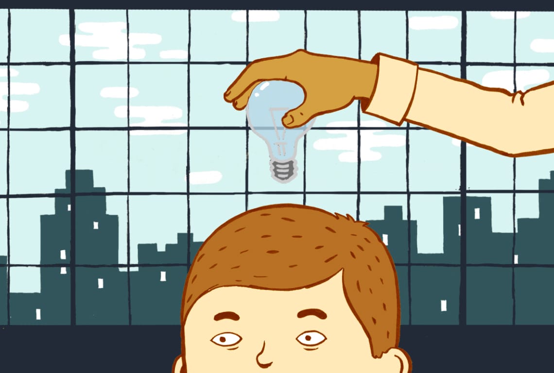 a hand is holding a light bulb over a man's head