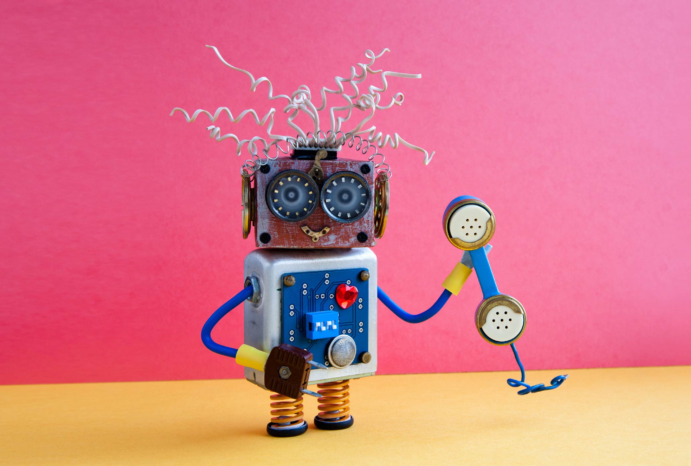 een speelgoedrobot praat door een telefoon