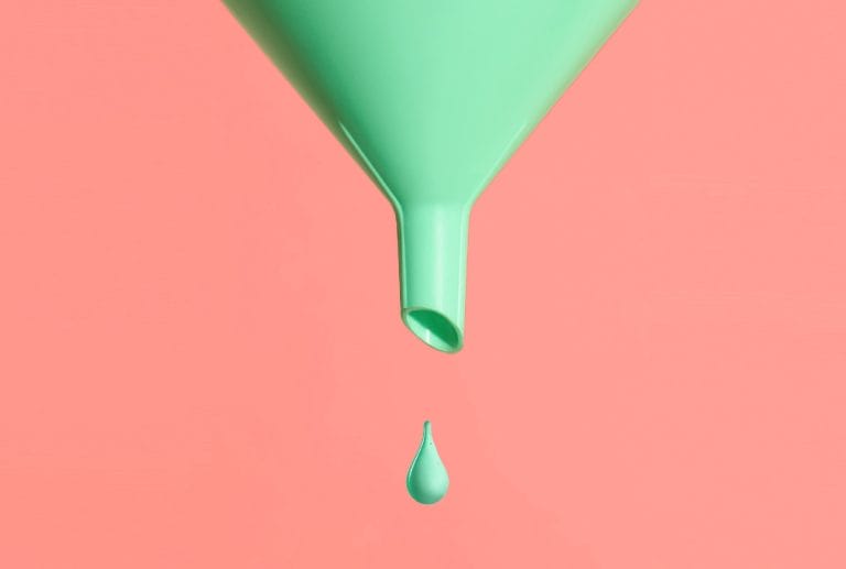 a green funnel with a drop of liquid coming out of it