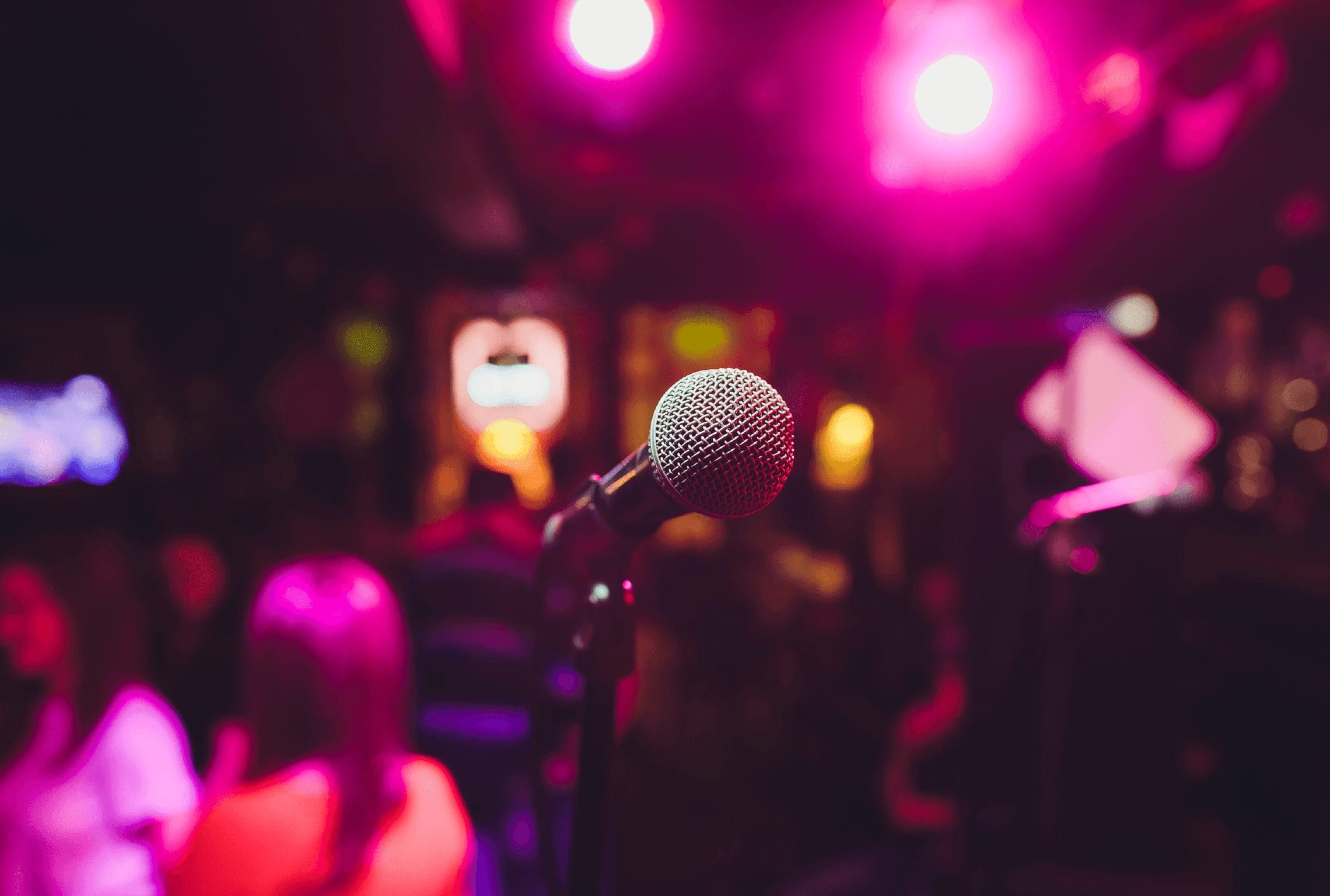 a microphone in front of a crowd with purple lights