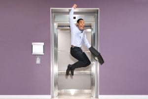 a man is jumping in the air while holding a briefcase in front of an elevator