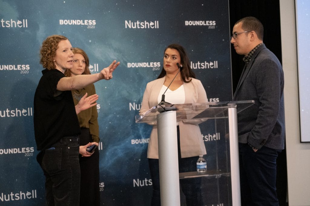 a group of people standing in front of podium at Boundless conference