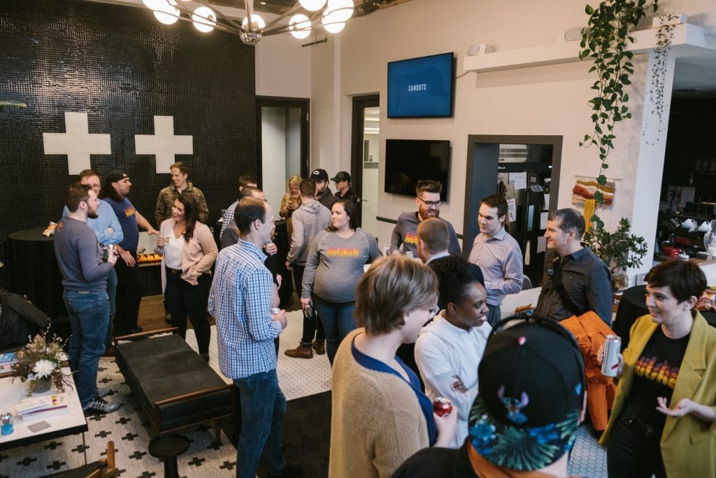 Nutshell staff members sitting in folding chairs and talking to each other