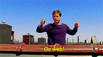 peter parker standing on a roof with a sign that says go web .