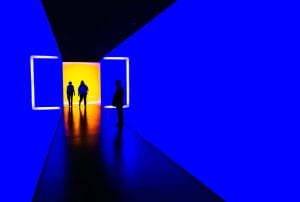 a group of people standing in front of a blue wall