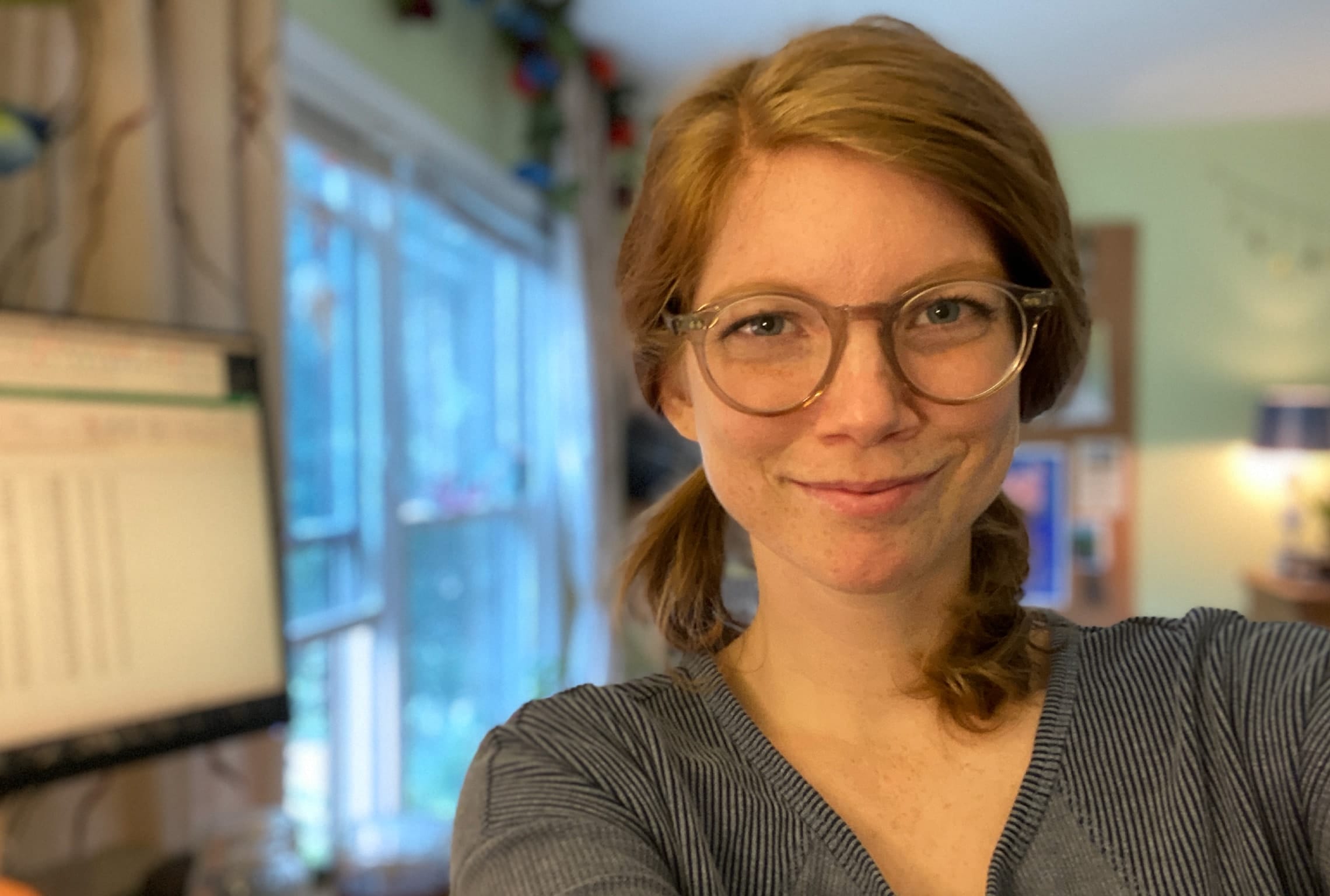 Katherine Mays stands in front of a computer monitor