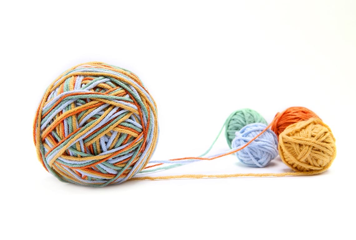 a ball of yarn is surrounded by other balls of yarn