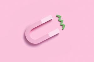 a pink magnet with a green zigzag coming out of it