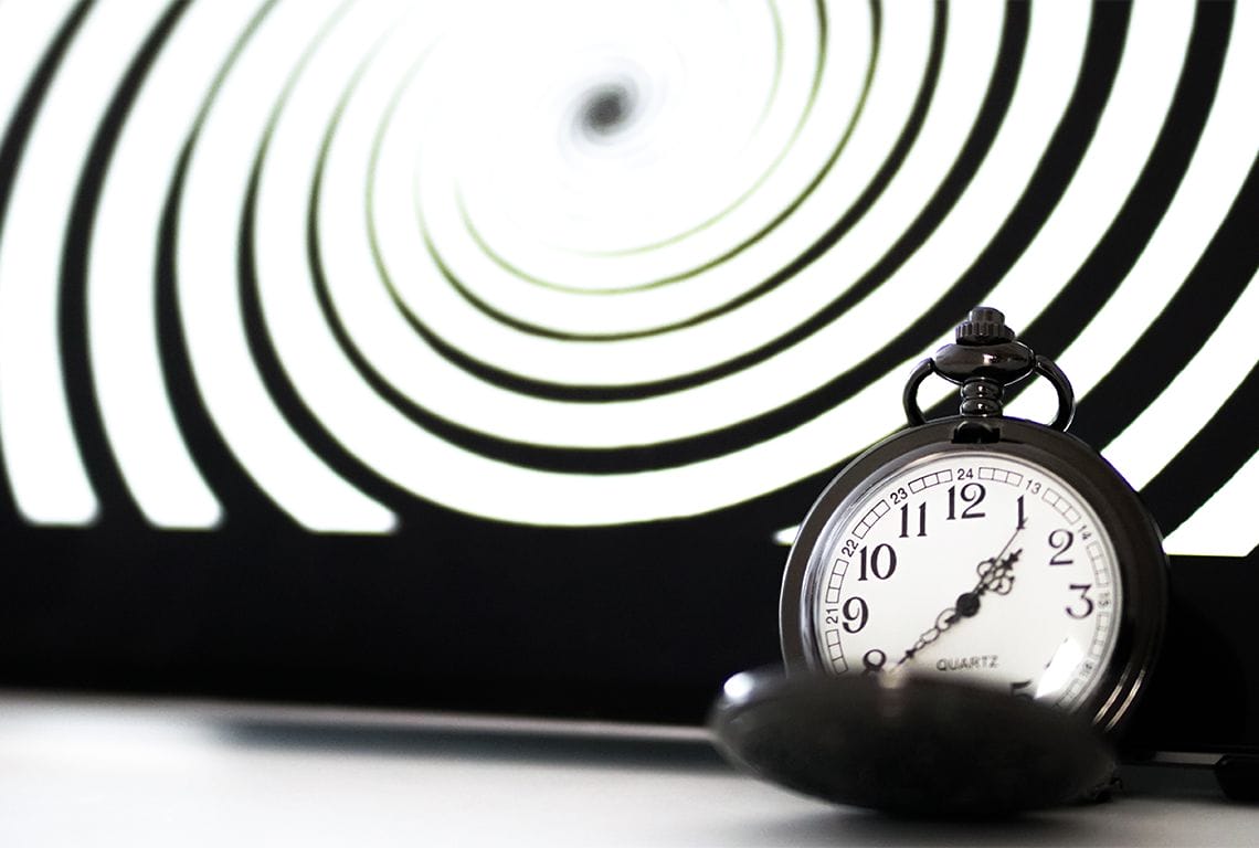 une montre de poche est placée devant une illusion d'optique