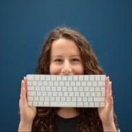a woman is holding a keyboard in front of her face