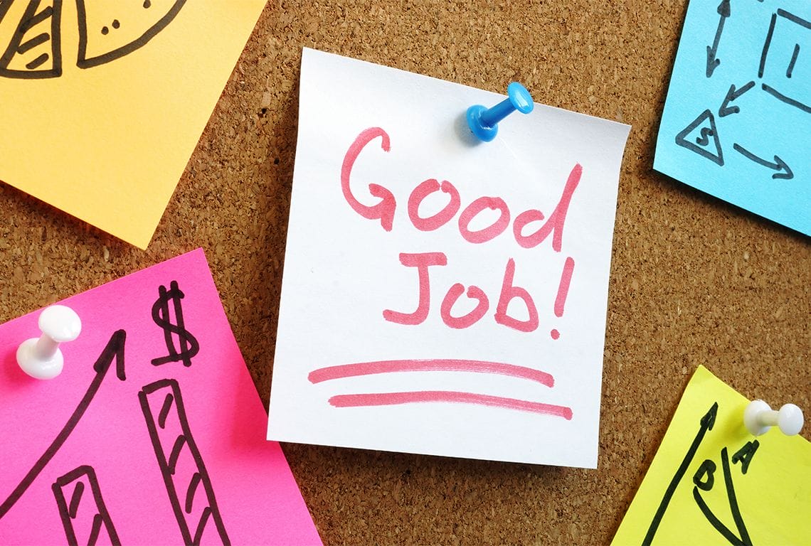 a post it note that says good job is pinned to a cork board