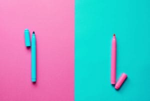 a blue and a pink marker on a pink and blue background