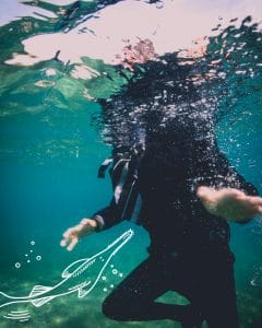 a person is swimming underwater in the ocean with a drawing of a fish