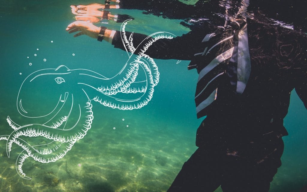a person in a suit and tie is underwater with a drawing of an octopus