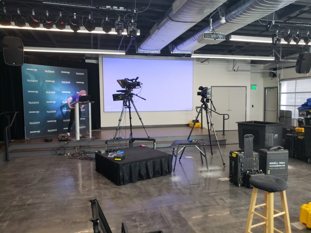 a person stands at a podium in front of a wall that says nutshell for the boundless conference