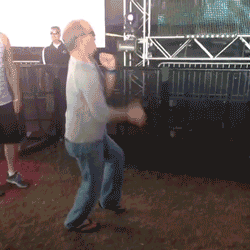 a man in a white shirt is dancing in front of a crowd