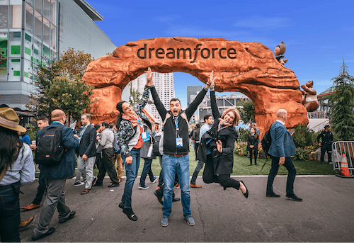 a group of people standing under a dreamforce sign