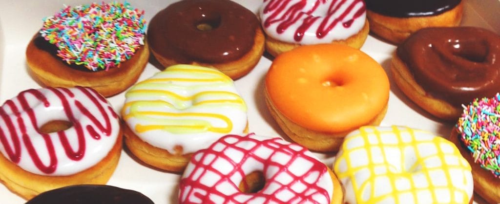 a box of donuts with different flavors and sprinkles