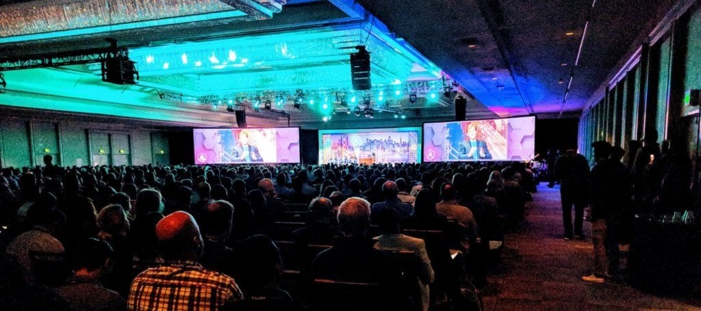 a large auditorium filled with people for the Saastr conference