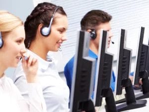 a group of people wearing headsets are working in a call center