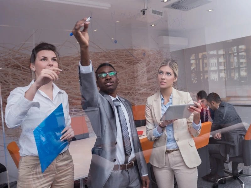 a group of people are looking at something on a glass wall