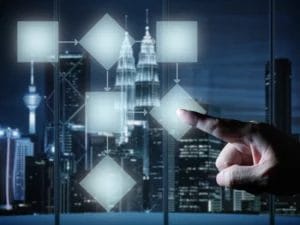 a hand pressing a button on a screen with a city in the background