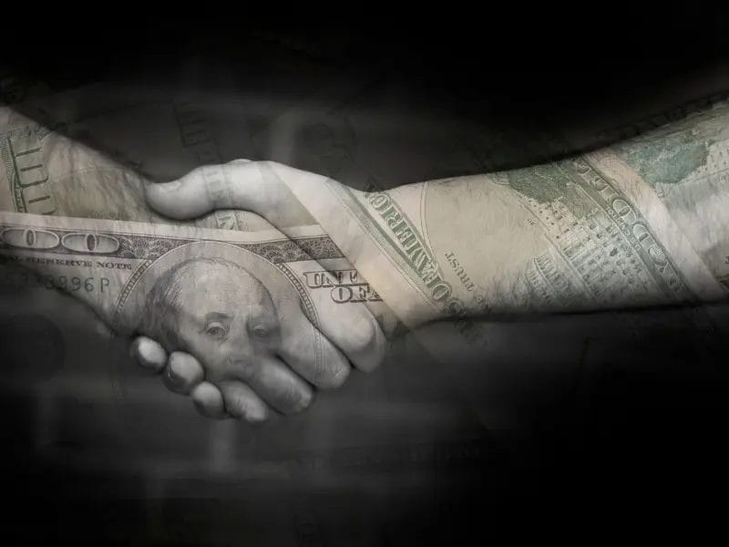 two people shaking hands with a 100 dollar bill imprinted on their skin