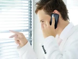 een man die mobiel belt terwijl hij uit het raam kijkt