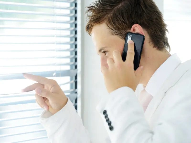 a man talking on a cell phone while looking out a window
