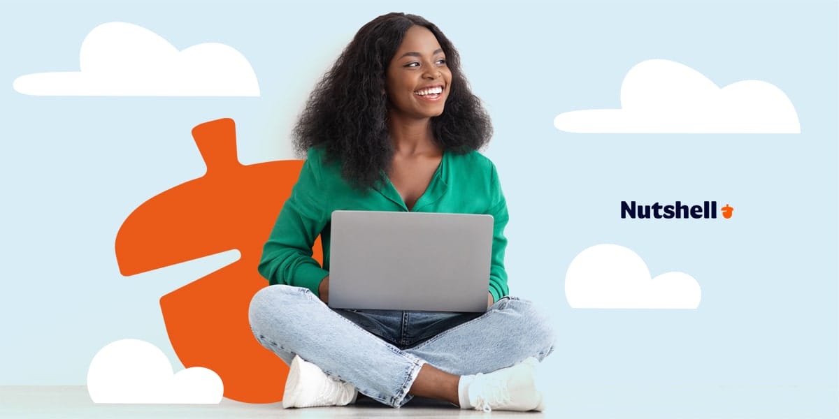 a woman is sitting on the floor with her legs crossed using a laptop with a Nutshell logo in the background