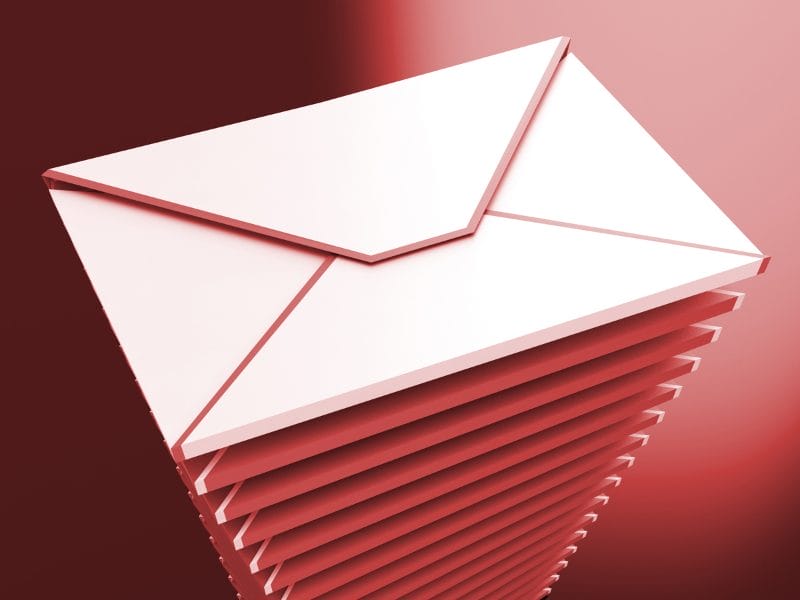 un sobre blanco sobre una pila de sobres rojos