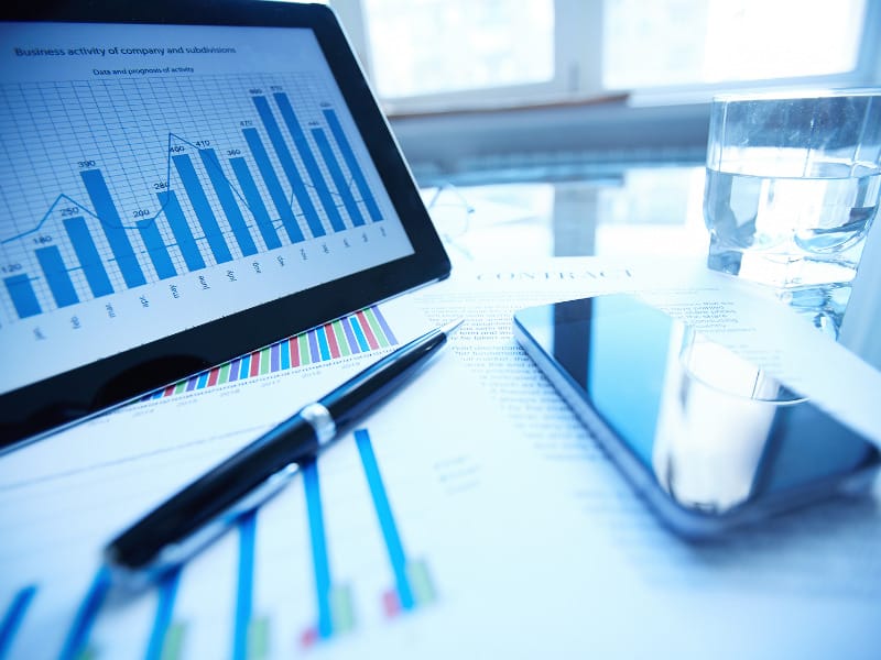 a tablet displays a graph that says business activity of company and subsidiaries