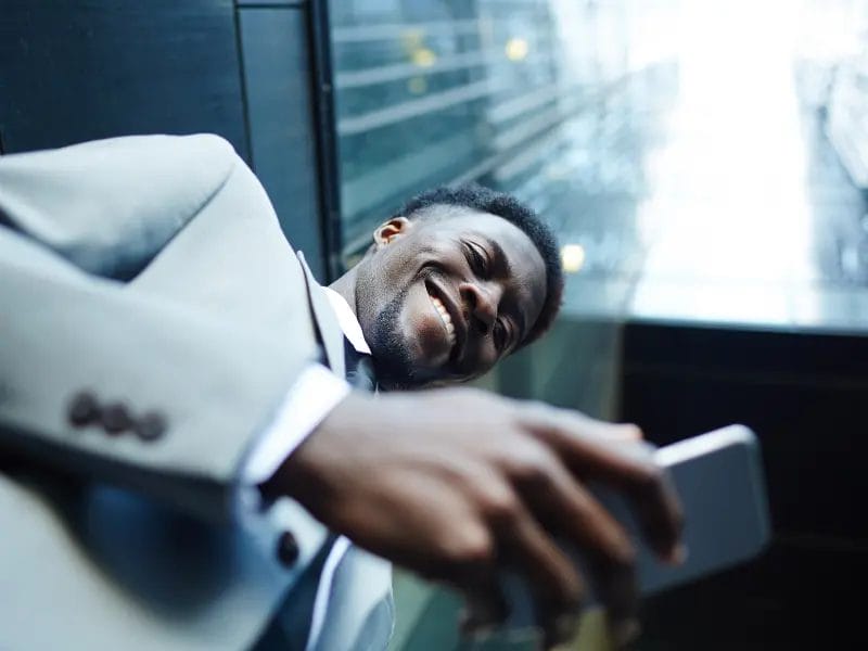 a man in a suit is taking a selfie with his cell phone .