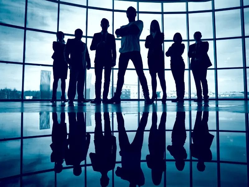 a group of people standing in front of a large window