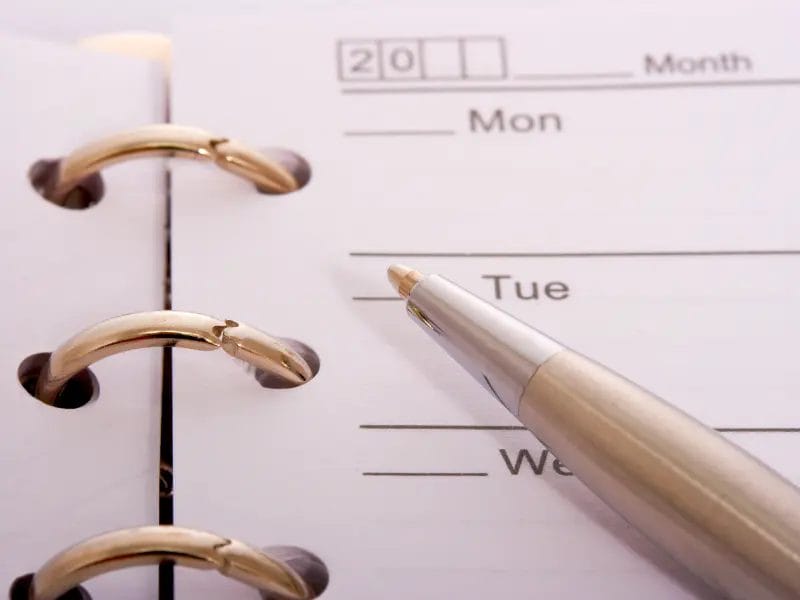 a pen is pointing at a calendar that says mon and tue